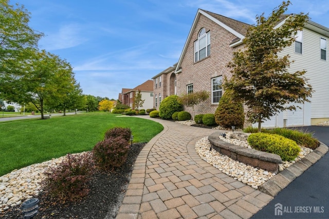 view of side of property with a garage and a lawn