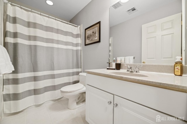 bathroom with toilet, vanity, and tile patterned flooring