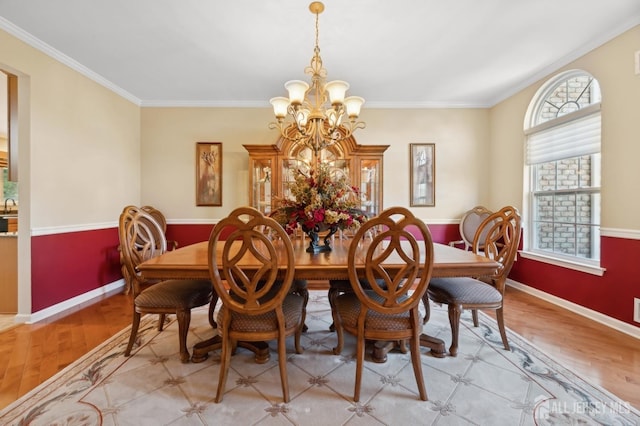 dining area featuring ornamental molding, light hardwood / wood-style flooring, and a notable chandelier