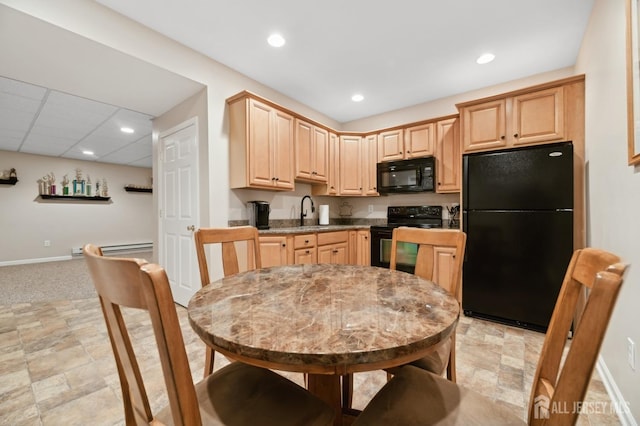 kitchen featuring light brown cabinetry, sink, a baseboard heating unit, and black appliances