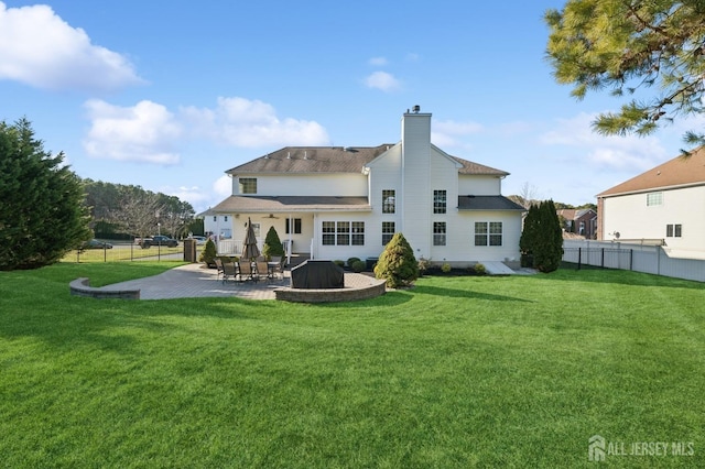 rear view of house with a lawn and a patio