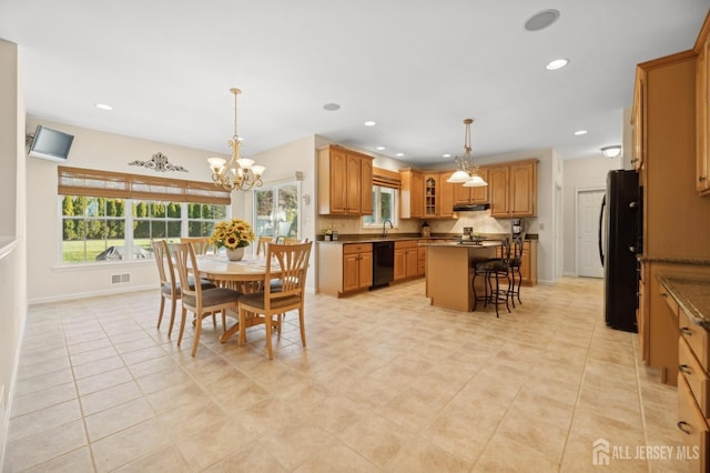 dining room with an inviting chandelier, light tile patterned flooring, and sink