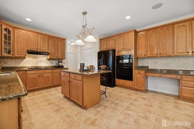 kitchen with pendant lighting, black appliances, a center island, a chandelier, and a breakfast bar