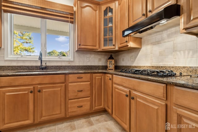 kitchen featuring black gas cooktop, decorative backsplash, sink, and dark stone countertops