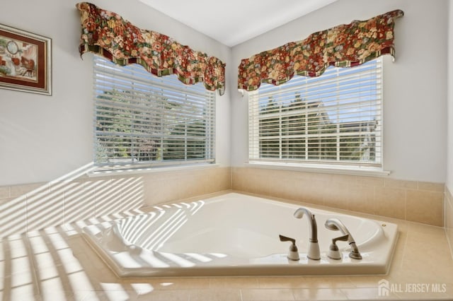 bathroom with tiled bath and plenty of natural light