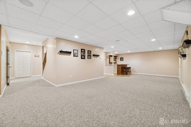 basement with a paneled ceiling and carpet floors