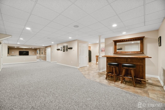 bar with light colored carpet and a drop ceiling