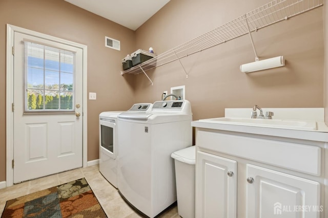 laundry area with sink, light tile patterned floors, and washing machine and clothes dryer