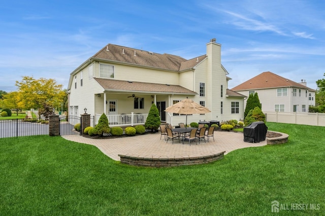 rear view of house with ceiling fan and a yard