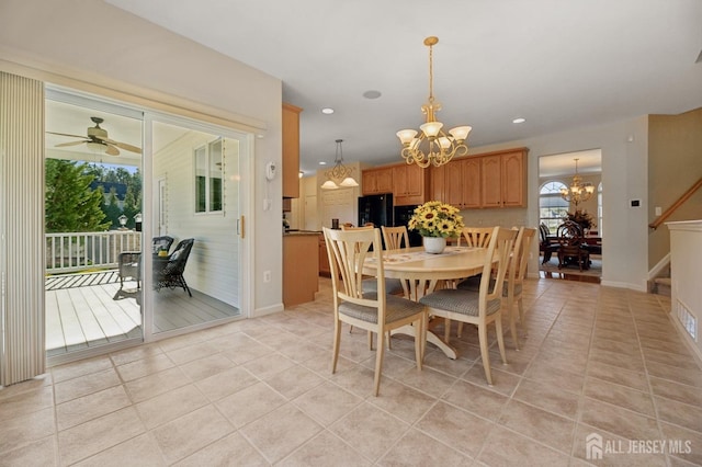 tiled dining area featuring ceiling fan with notable chandelier