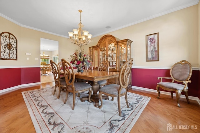 dining area with a chandelier, crown molding, and wood-type flooring