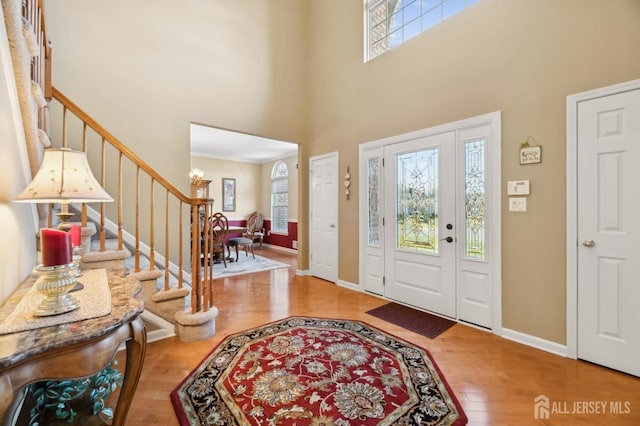 foyer entrance featuring a high ceiling, hardwood / wood-style floors, and an inviting chandelier