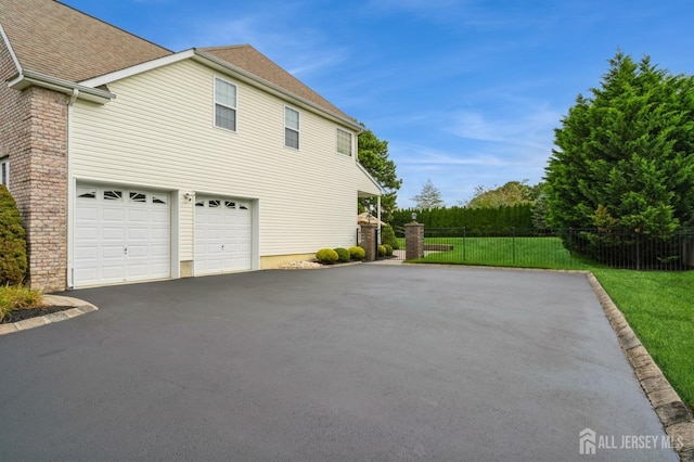 view of side of home featuring a garage and a lawn