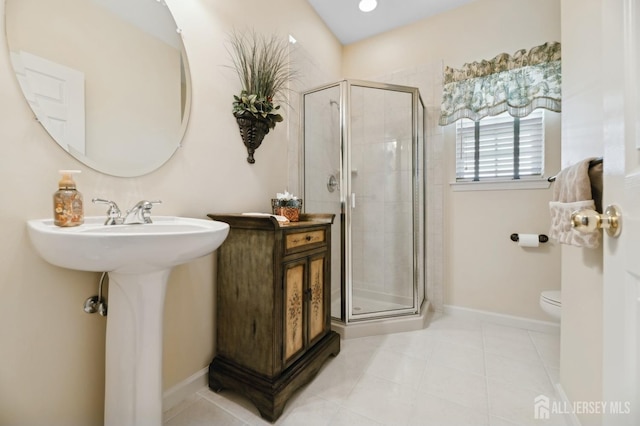 bathroom with toilet, tile patterned floors, walk in shower, and sink