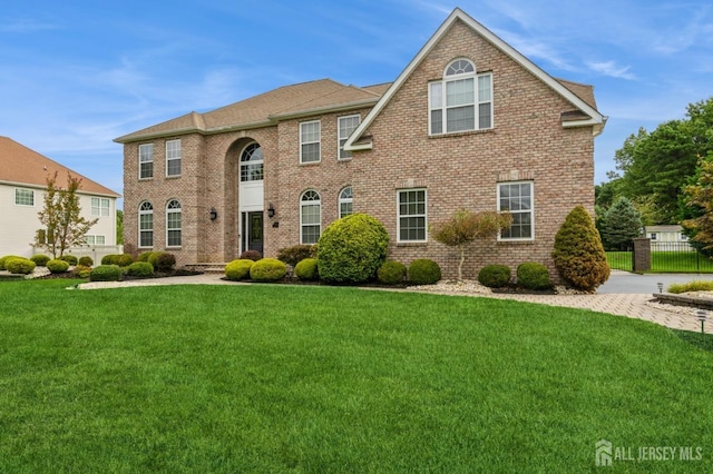 colonial inspired home featuring a front lawn