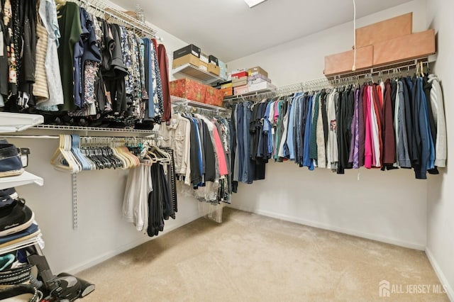 spacious closet featuring light colored carpet