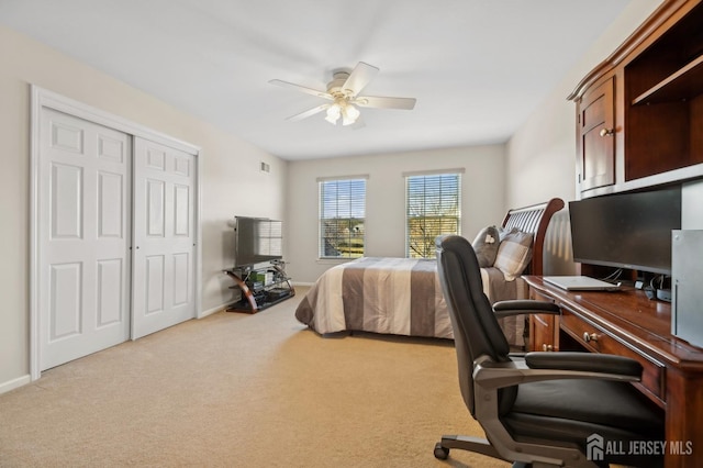 carpeted bedroom with ceiling fan and a closet