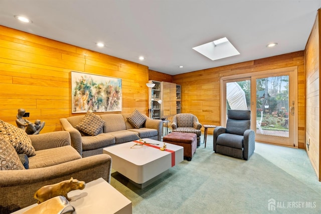 carpeted living room with wooden walls and a skylight