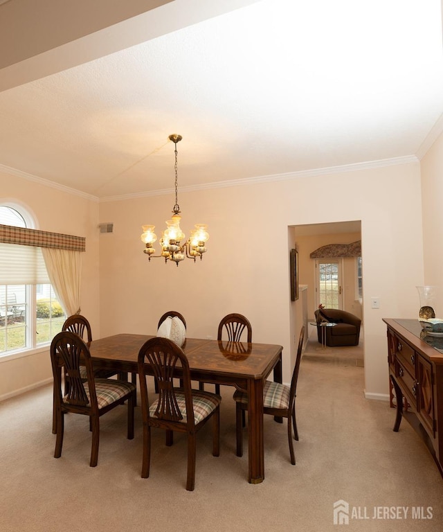 dining space featuring a notable chandelier, ornamental molding, plenty of natural light, and light colored carpet