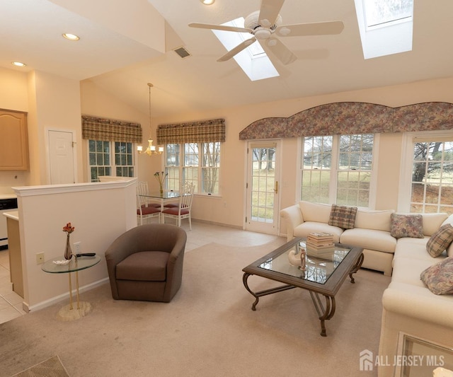 living area featuring light colored carpet, vaulted ceiling with skylight, a healthy amount of sunlight, and visible vents