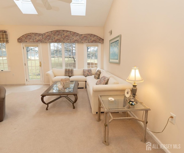 living room featuring vaulted ceiling with skylight, carpet flooring, and baseboards