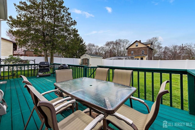 deck with a yard, an outdoor structure, outdoor dining area, and a shed