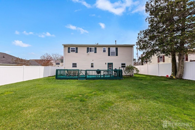 back of house featuring a fenced backyard and a lawn