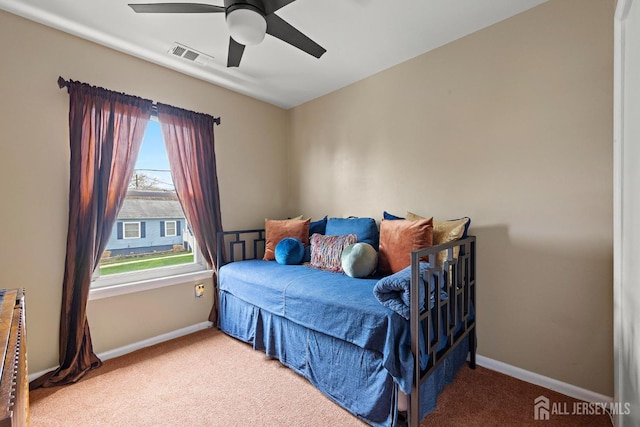 carpeted bedroom featuring baseboards, a ceiling fan, and visible vents