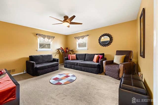 living area featuring carpet flooring, visible vents, baseboards, and ceiling fan