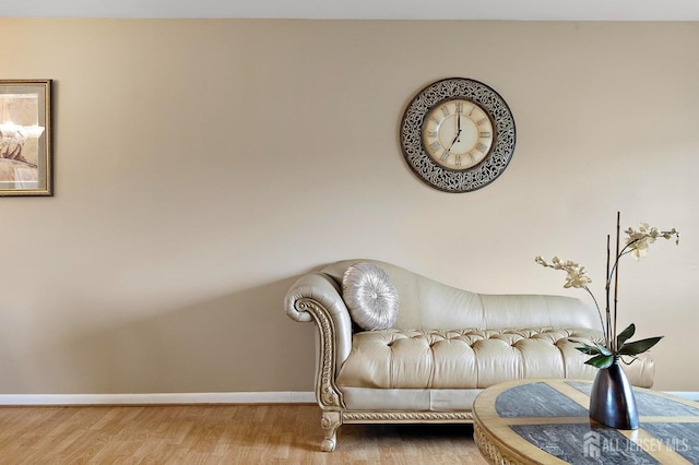 living area with baseboards and wood finished floors