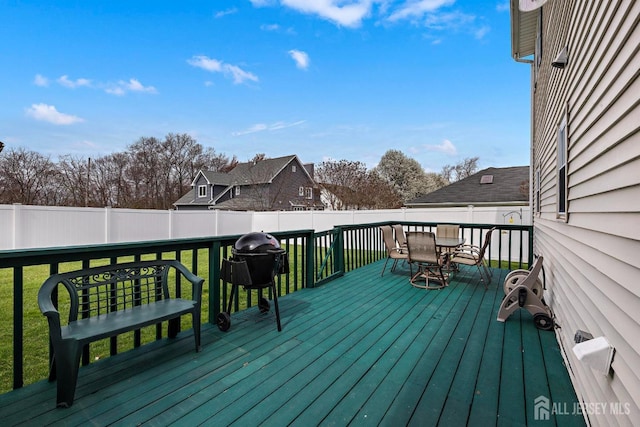 wooden terrace with a yard, a fenced backyard, and outdoor dining area