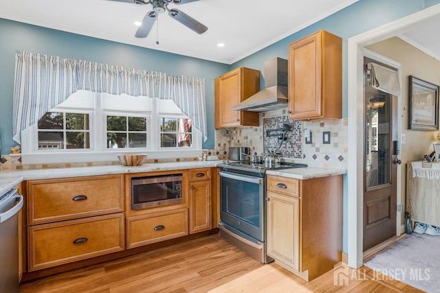 229 Harris Ave, Middlesex, NJ 08846 - kitchen featuring appliances with stainless steel finishes, wall chimney exhaust hood, light wood-type flooring, decorative backsplash, and ceiling fan