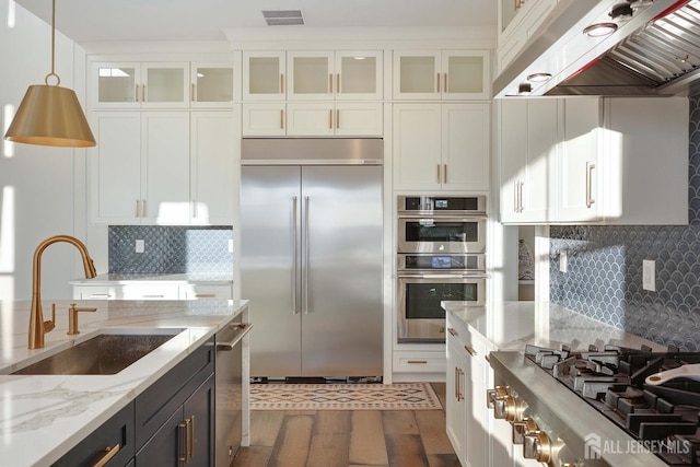 21 Cole Pl, Cranbury, NJ 08512 - kitchen with appliances with stainless steel finishes, a sink, range hood, white cabinets, and hanging light fixtures