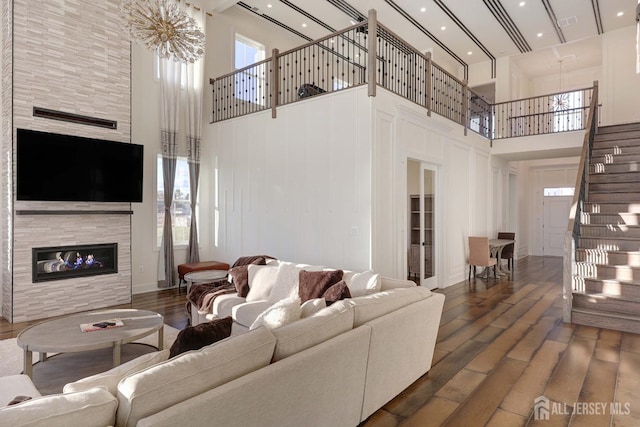 21 Cole Pl, Cranbury, NJ 08512 - living room with a high ceiling, a tiled fireplace, stairs, wood finished floors, and recessed lighting
