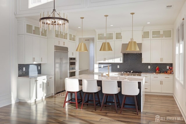 21 Cole Pl, Cranbury, NJ 08512 - kitchen with stainless steel appliances, extractor fan, backsplash, a kitchen island with sink, and white cabinetry