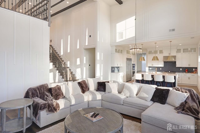 21 Cole Pl, Cranbury, NJ 08512 - living room with a high ceiling, stairs, and a chandelier