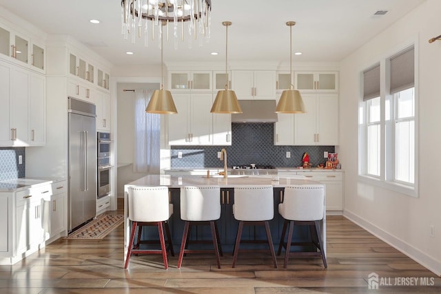 21 Cole Pl, Cranbury, NJ 08512 - kitchen with tasteful backsplash, an island with sink, wood finished floors, white cabinets, and a breakfast bar area