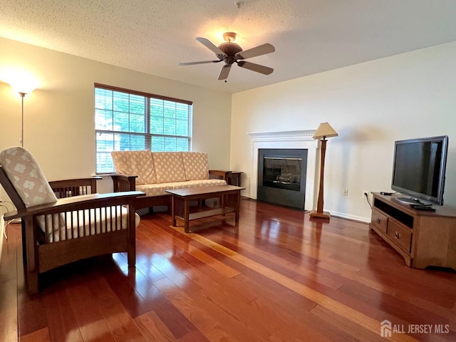 116 Prestwick Way, Edison, NJ 08820 - living room with wood finished floors, ceiling fan, a glass covered fireplace, and a textured ceiling