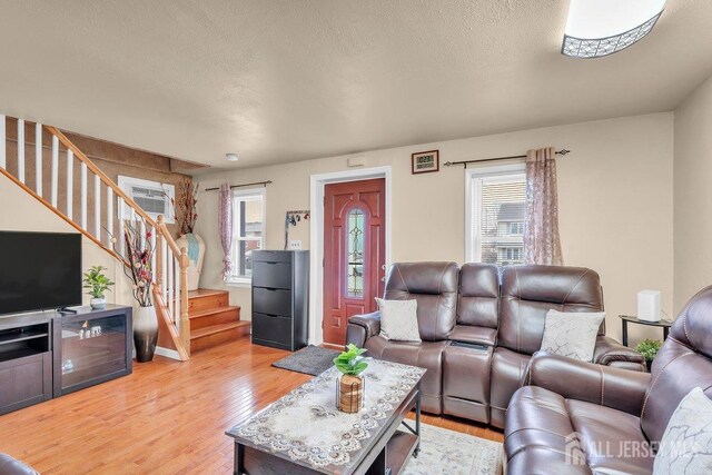 living room with light hardwood / wood-style floors and a textured ceiling