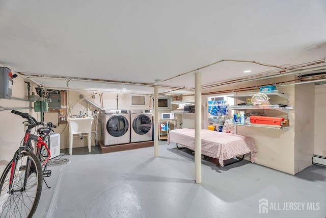 basement featuring washing machine and clothes dryer, electric panel, and sink