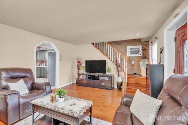 living room with hardwood / wood-style flooring and a wall mounted air conditioner