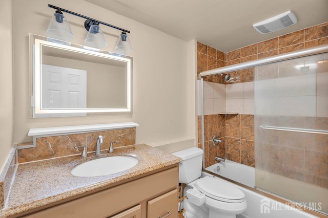 full bathroom featuring vanity, enclosed tub / shower combo, and toilet