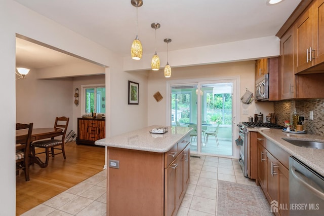 34 Bartman Rd, East Brunswick, NJ 08816 - kitchen featuring light tile patterned floors, appliances with stainless steel finishes, tasteful backsplash, a kitchen island, and brown cabinetry