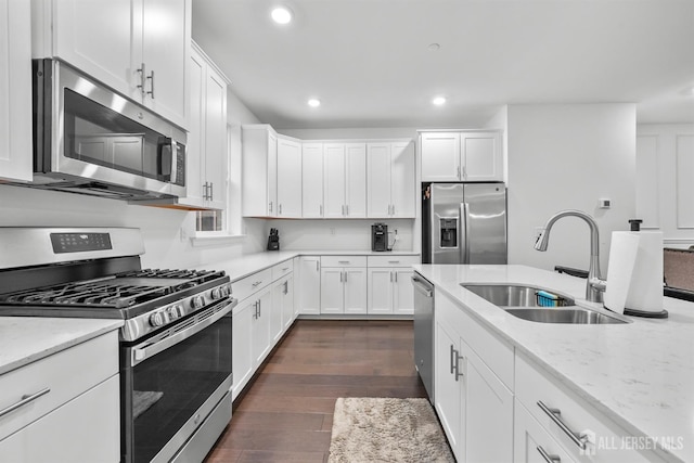 kitchen with dark wood-type flooring, a sink, recessed lighting, appliances with stainless steel finishes, and white cabinets