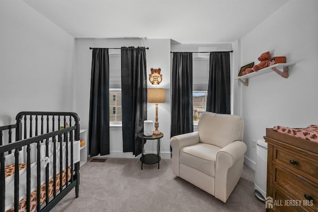 bedroom with a crib, baseboards, and carpet floors