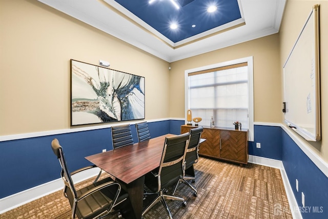 carpeted office space with baseboards, crown molding, and a tray ceiling