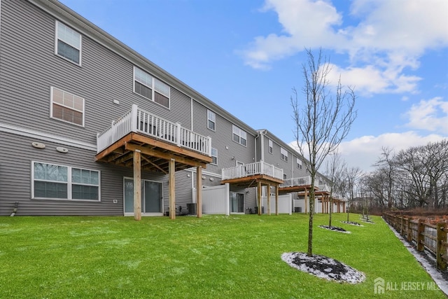 back of property featuring central AC unit, a lawn, and a wooden deck