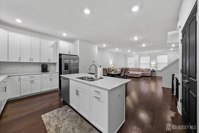 kitchen featuring a sink, stainless steel appliances, dark wood-style floors, and white cabinets