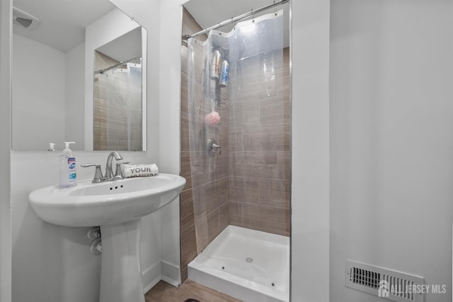 bathroom with visible vents and a shower stall