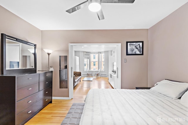 bedroom with ceiling fan, light wood-type flooring, and baseboards